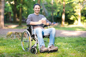 Disabled man using a tablet in a park
